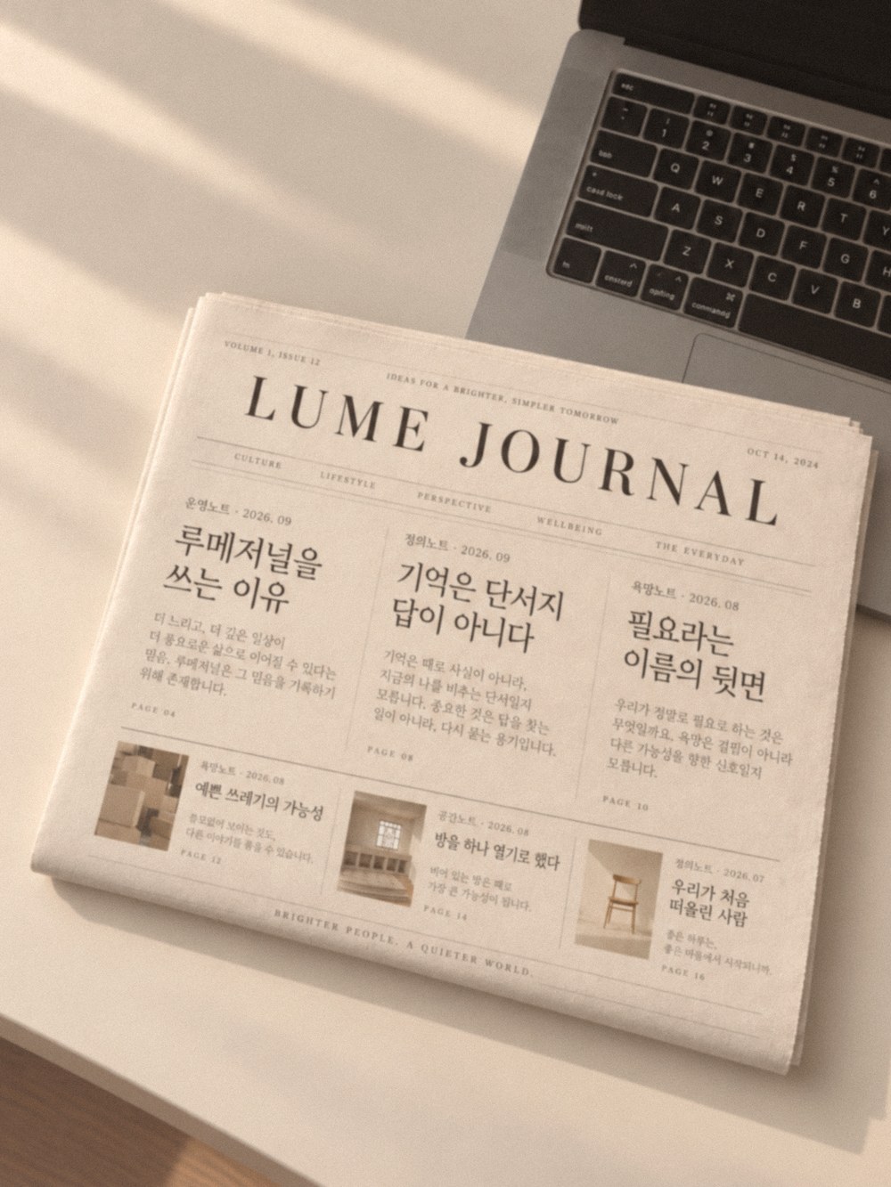 루메저널이라 적힌 신문과 노트북이 놓인 책상